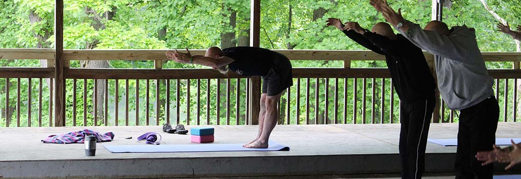 An instructor leads morning yoga class in the dance pavillion