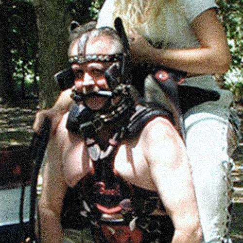 a man in pony gear, with a woman riding on his shoulders